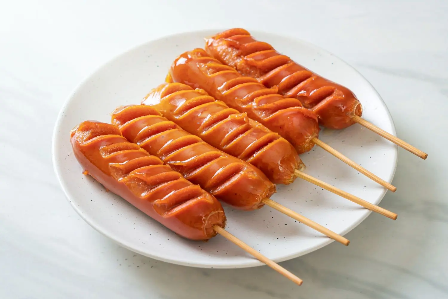 Slit grilled sausages on skewers with glossy glaze at Foodie BBQ & Bar, a Chinese Restaurant in New York